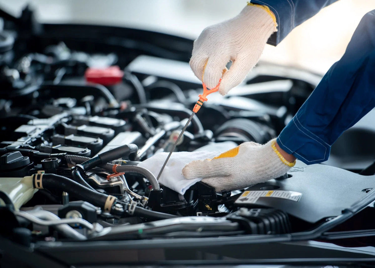 Person working on a car engine with tools